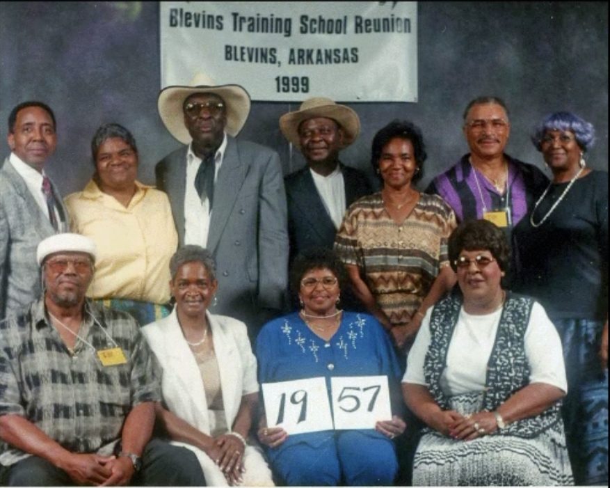 Members of the Class of 1957 hold up their class-year card at the 1999 Blevins reunion.