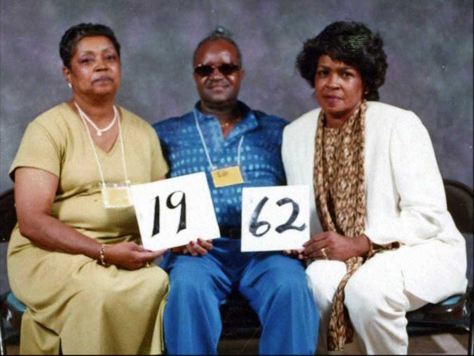 Members of the Class of 1962 hold up their class-year card at the 1999 Blevins reunion.
