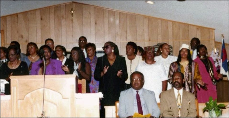 A choir of alumni stands behind the pulpit during the 1999 reunion worship service.